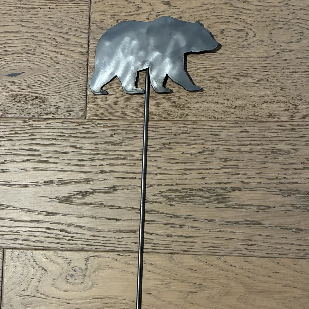 Steel yard stake shaped like a walking bear.