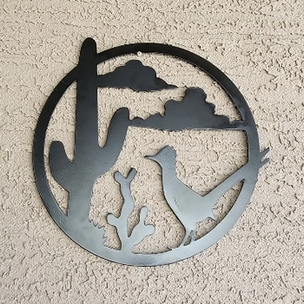 Steel desert round with a saguaro, clouds and a roadrunner.