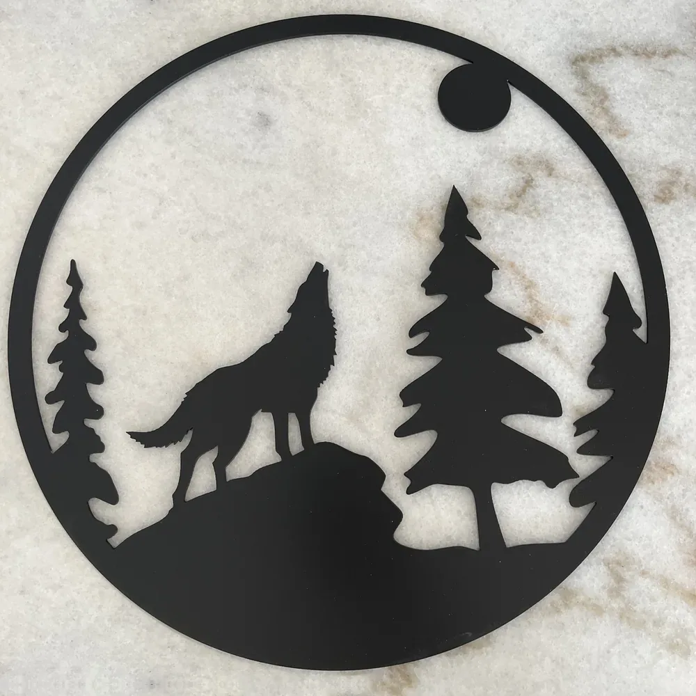 Black steel round with a howling coyote, pine trees and the moon.